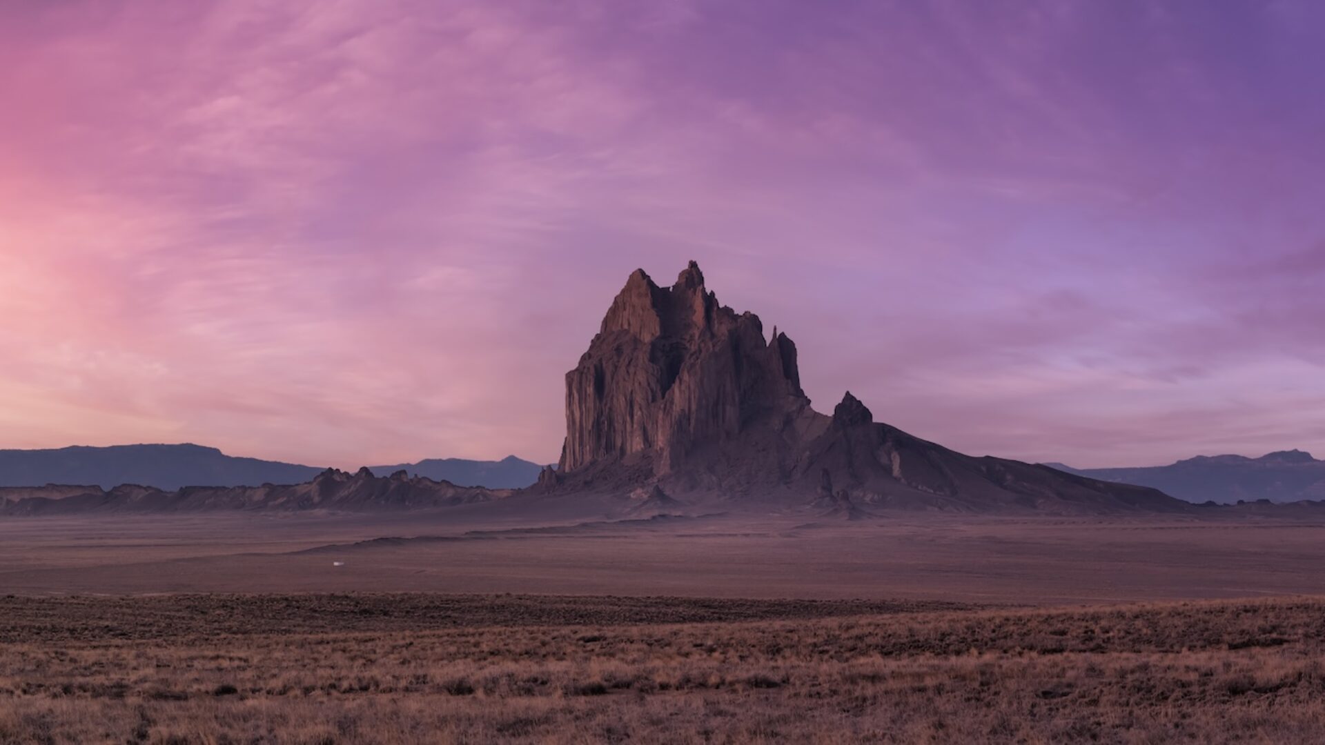 Panoramic American Nature Landscape View of the Dry Desert and Rugged Rocky Mountains. Colorful Sunrise Sky Art Render. Taken at Shiprock, New Mexico, United States.