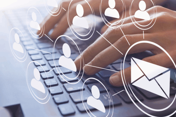 Image of person typing with email icon connecting to users